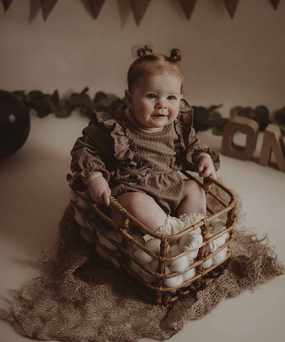 Baby met blote voetjes die een taart ontdekt tijdens een cakesmash-shoot